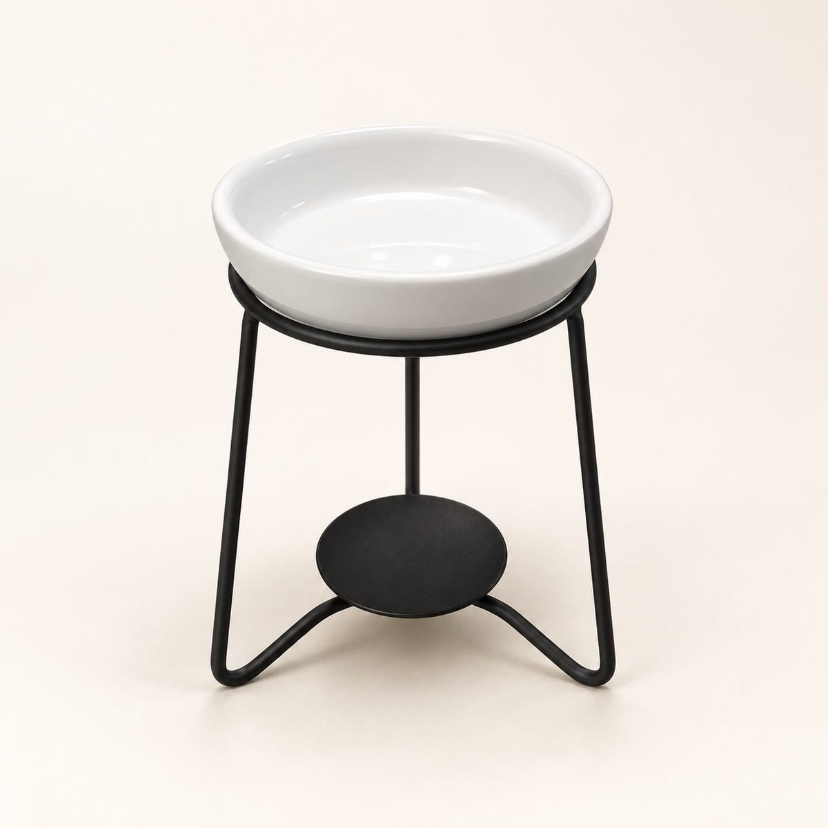 White ceramic wax melt burner on a black metal stand against a warm cream background
