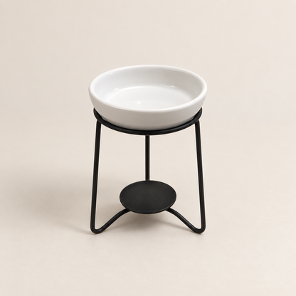 Front view of a white ceramic wax melt burner with fitted dish and black metal stand