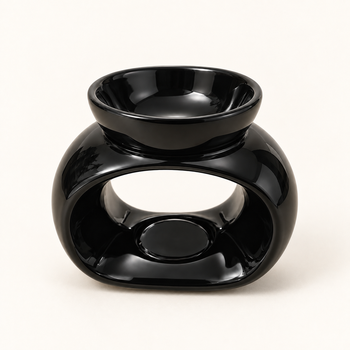 Front view of a glossy black oval ceramic wax melt burner on a warm cream background.